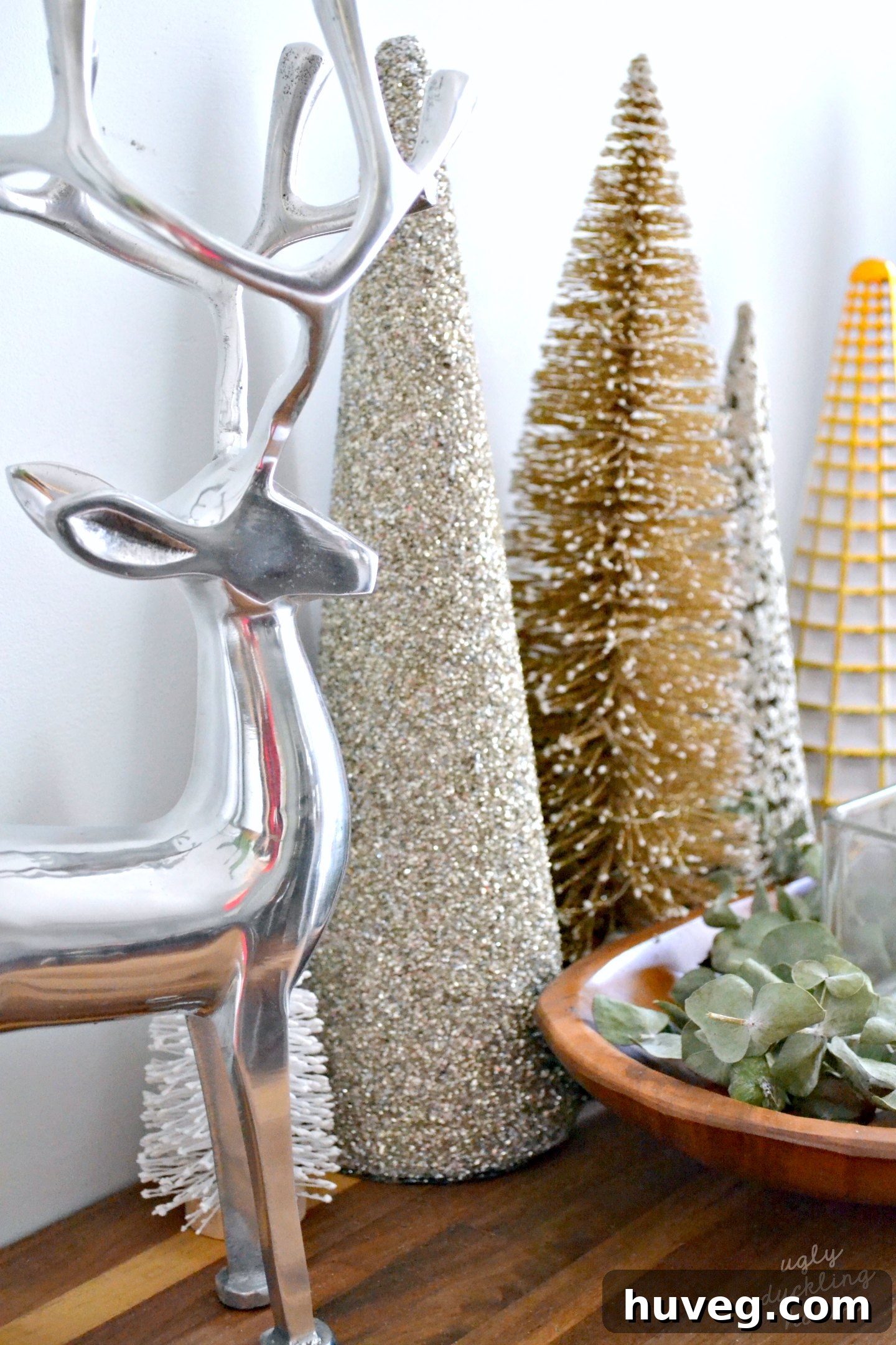 A beautiful gold, white, and silver treescape arrangement in the kitchen, exemplifying a serene neutral Christmas aesthetic.