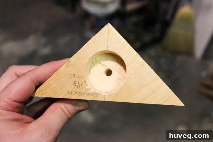 Applying a rich wood stain to a finished triangle tea light holder, demonstrating how different finishes can transform the aesthetic.