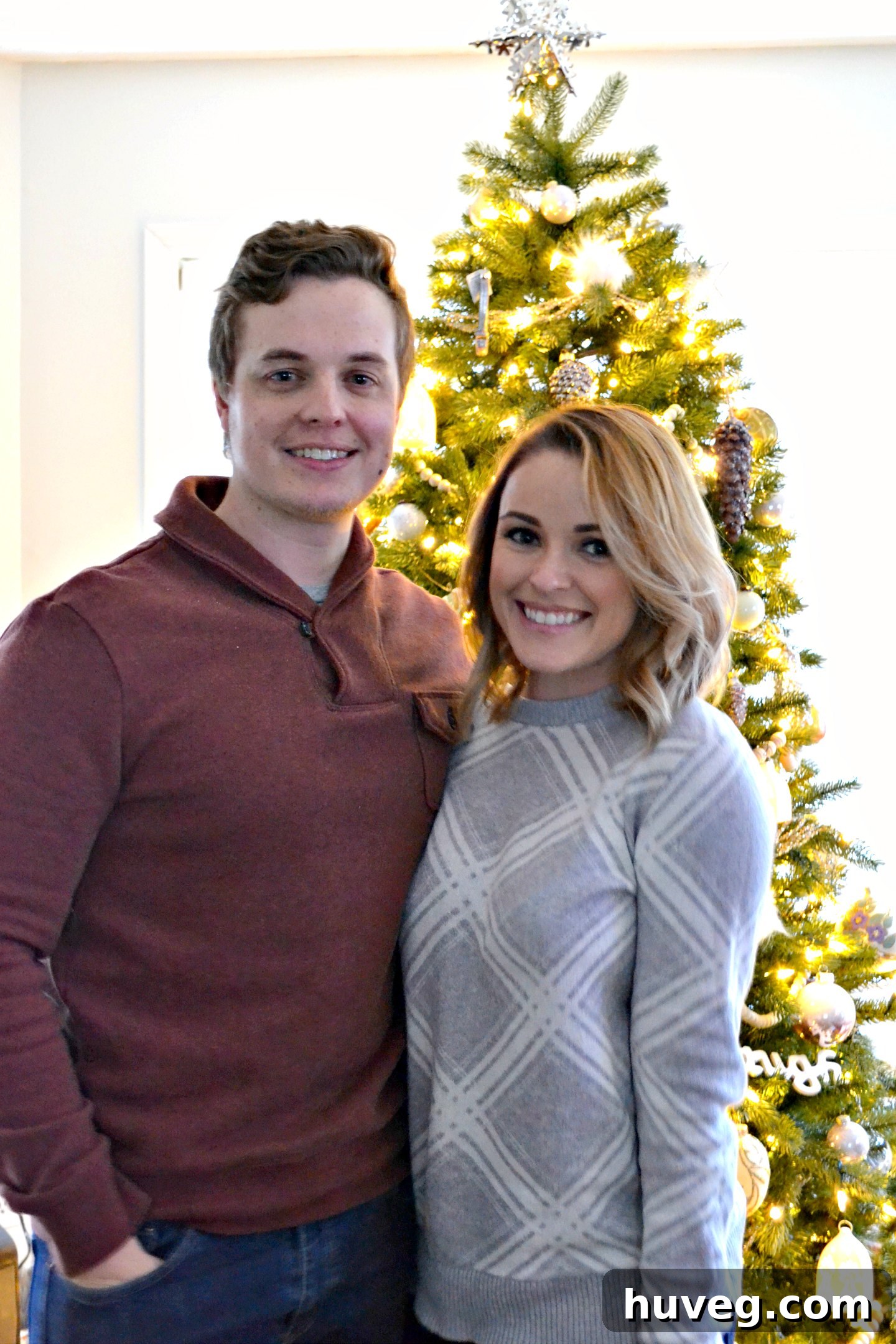 Emily and Brock, my sister and her boyfriend, smiling brightly in a festive Christmas photo.