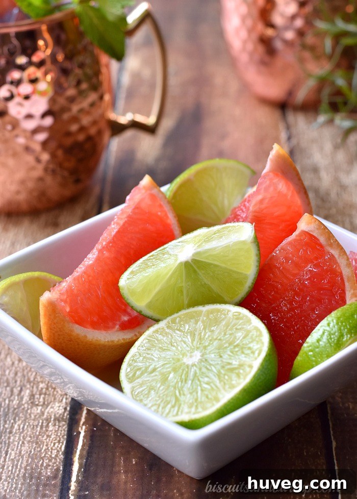 Two hands holding copper mugs with grapefruit Moscow Mules.