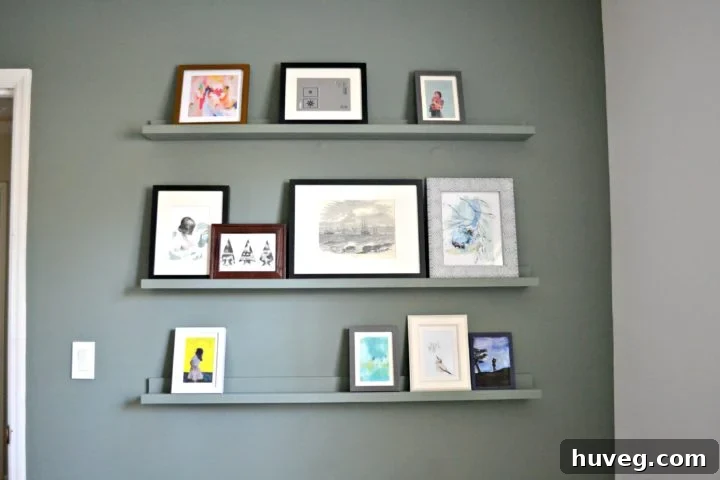 Beautifully painted picture ledge shelves displaying various art pieces in a guest bedroom
