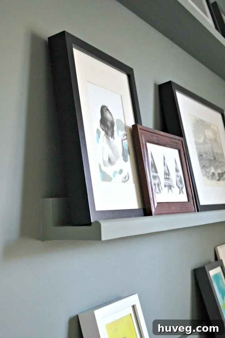 Close-up view of a custom-built picture ledge shelf in a guest room, showcasing its rounded edge and wall-matched paint