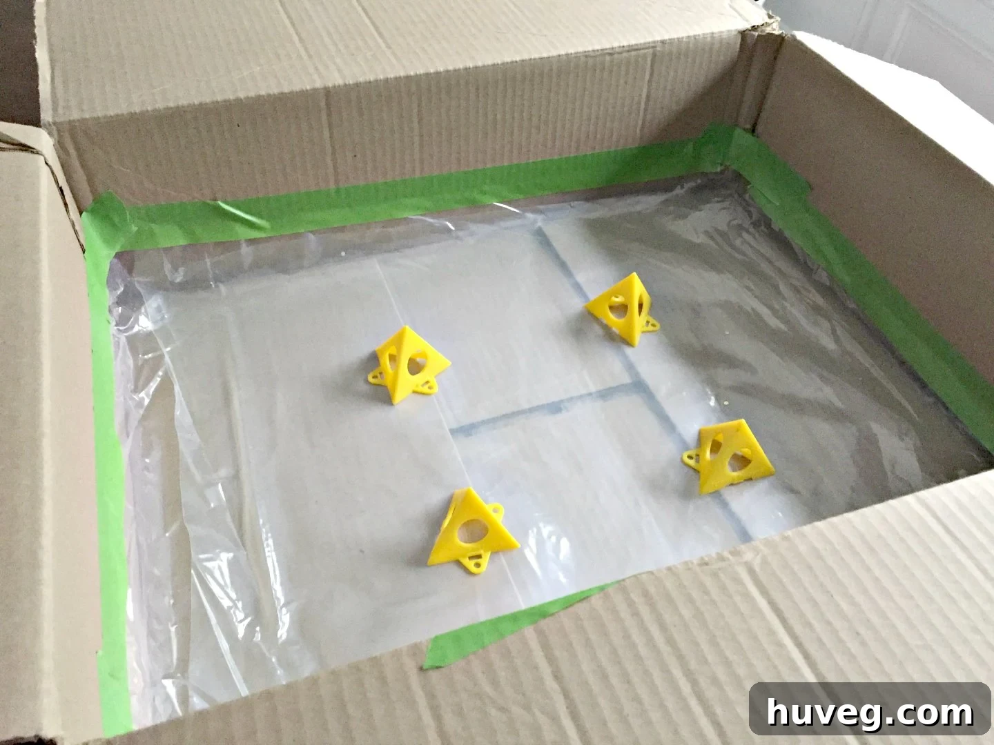 cardboard box with plastic lining and plastic pyramids to support painting