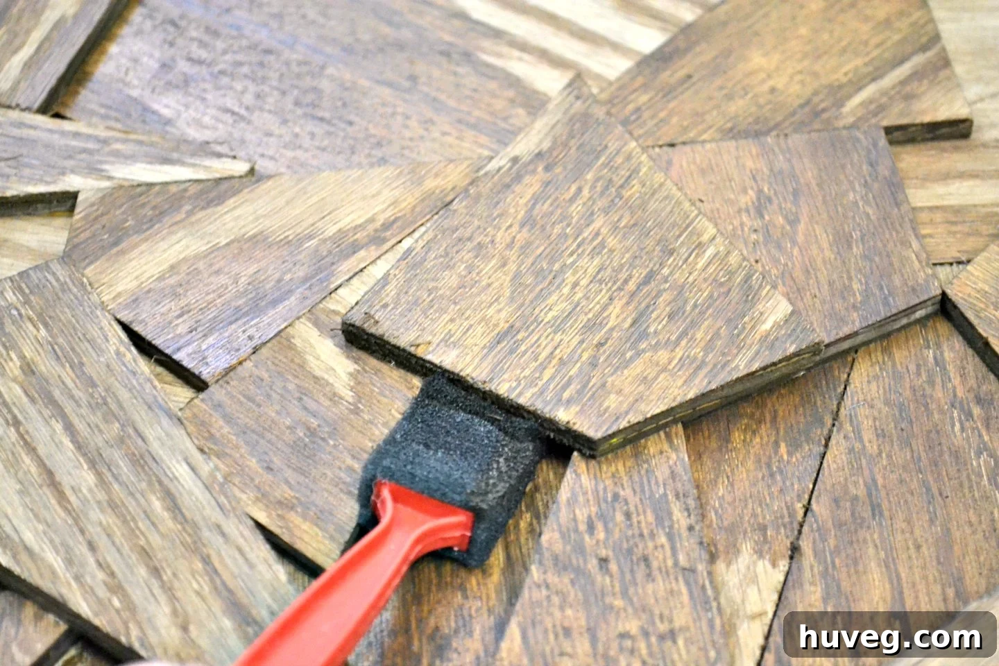Using a red-handled sponge brush, I meticulously reached into every nook and cranny of my reclaimed wood, ensuring even application.