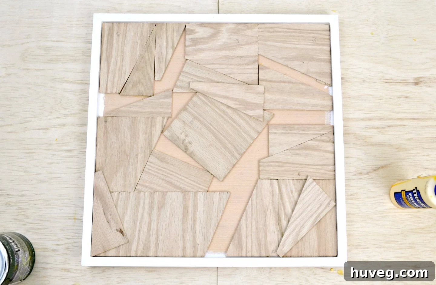 I meticulously assembled an array of reclaimed wood pieces within the frame, securing each with glue to form the textured background for the wall art.