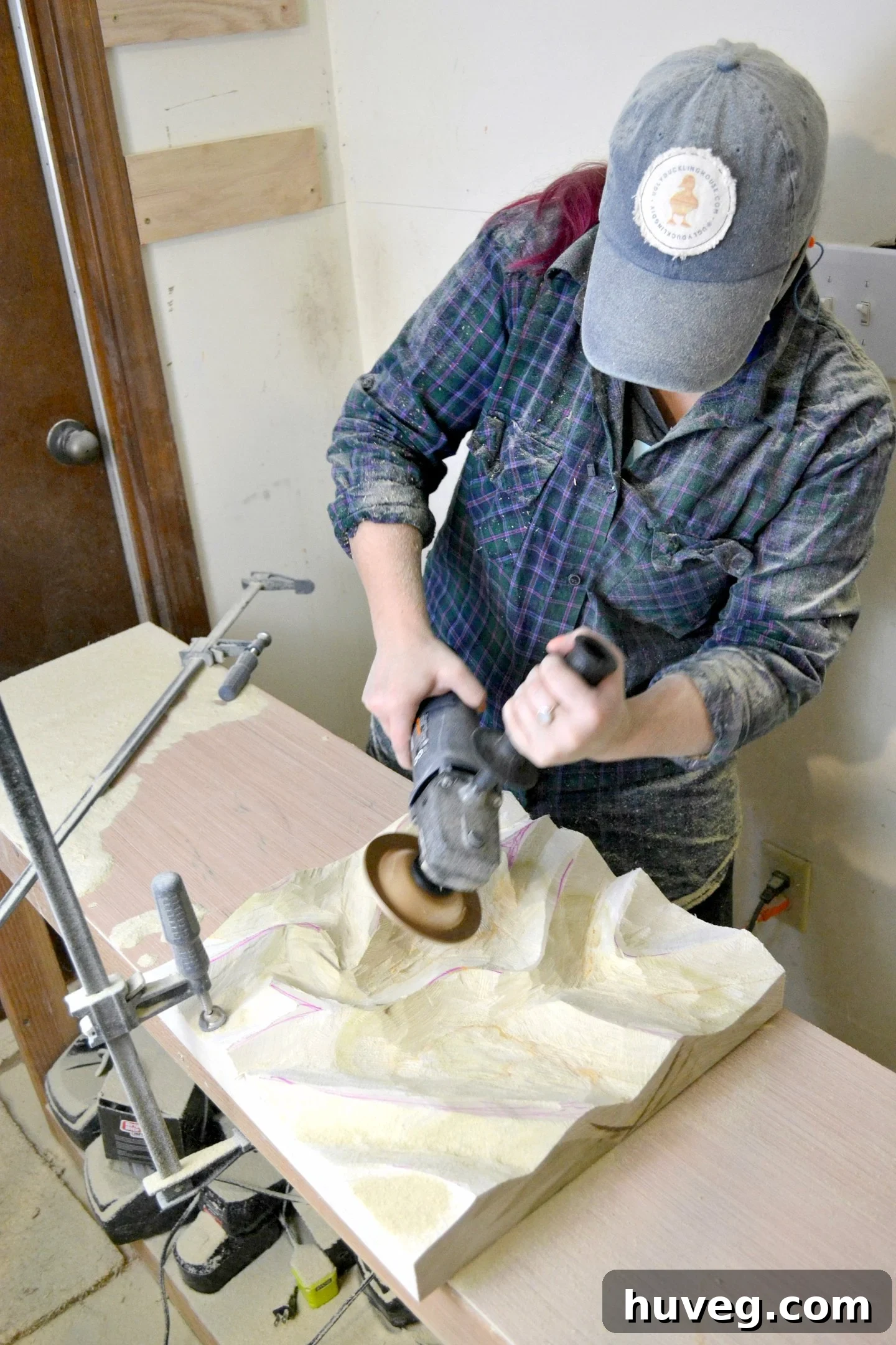 Sarah carving wood for wood art challenge, demonstrating use of new narrow workbench.