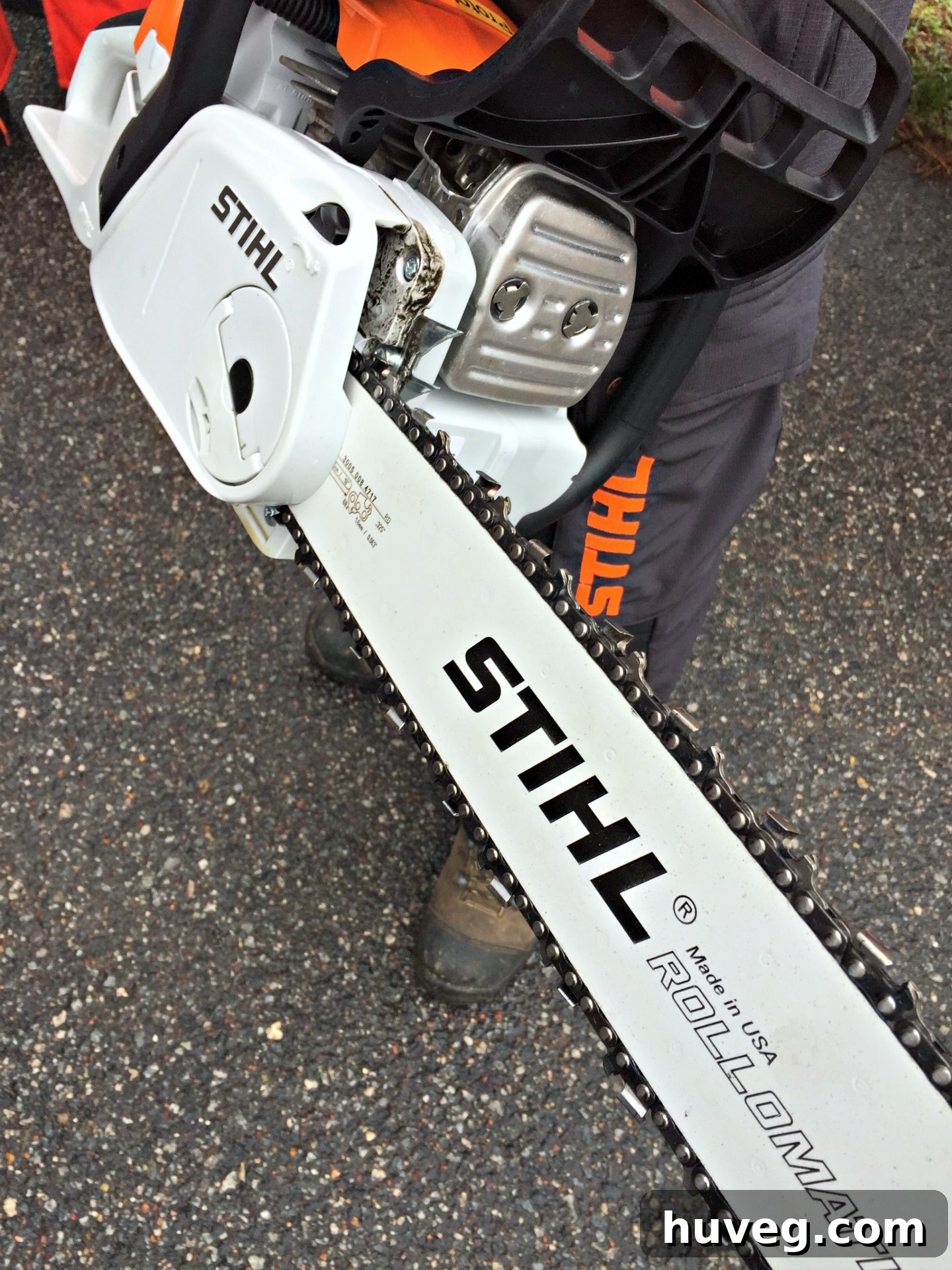 Woman proudly holding a STIHL chainsaw in safety gear