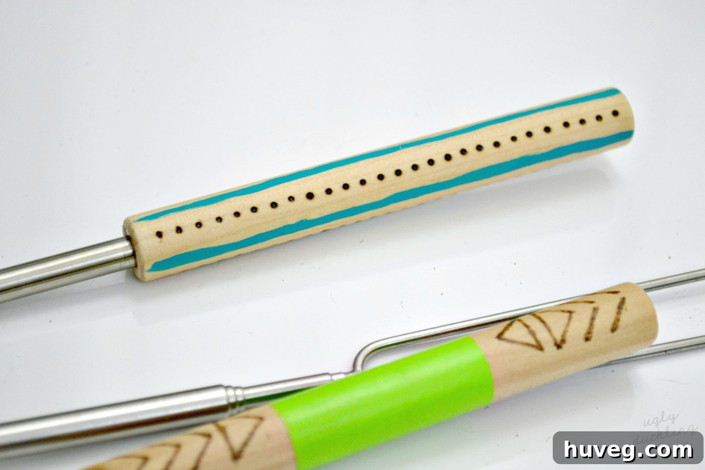 Close-up of a finished personalized roasting stick handle with wood burning, paint, and protective finish