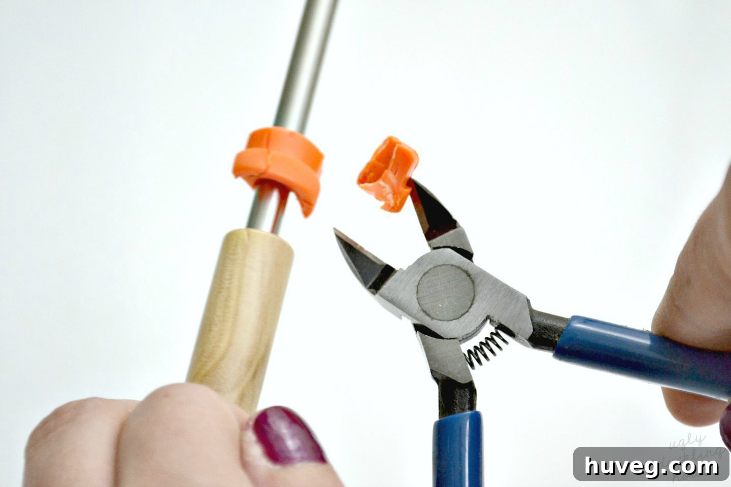 Using cutting pliers to remove the colored plastic caps from roasting sticks