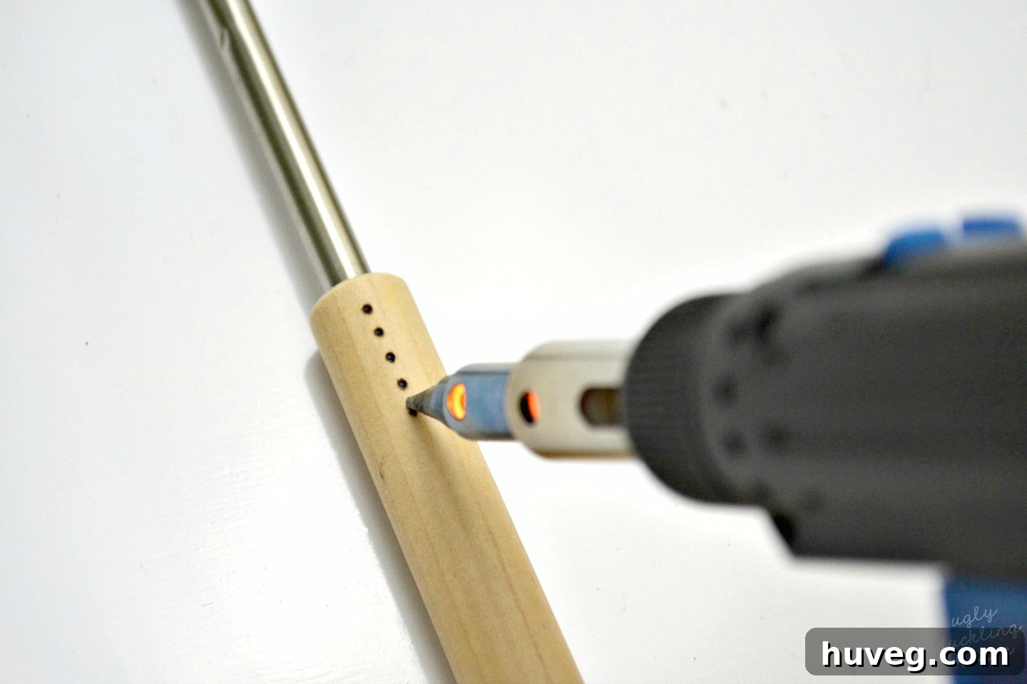 Beginning the first wood burn design on a roasting stick handle, starting with dots