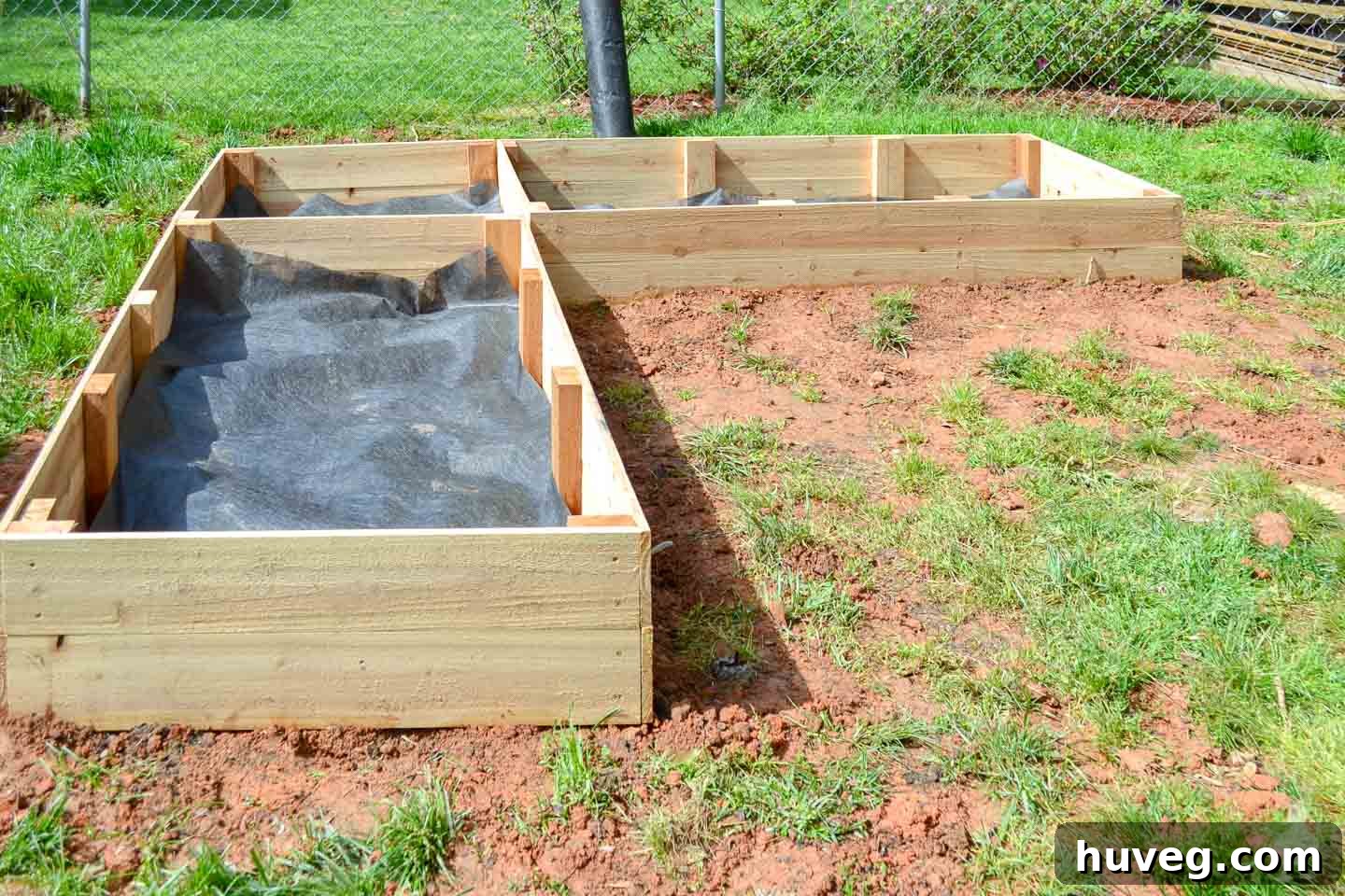 raised garden beds with landscaping fabric lining bottom
