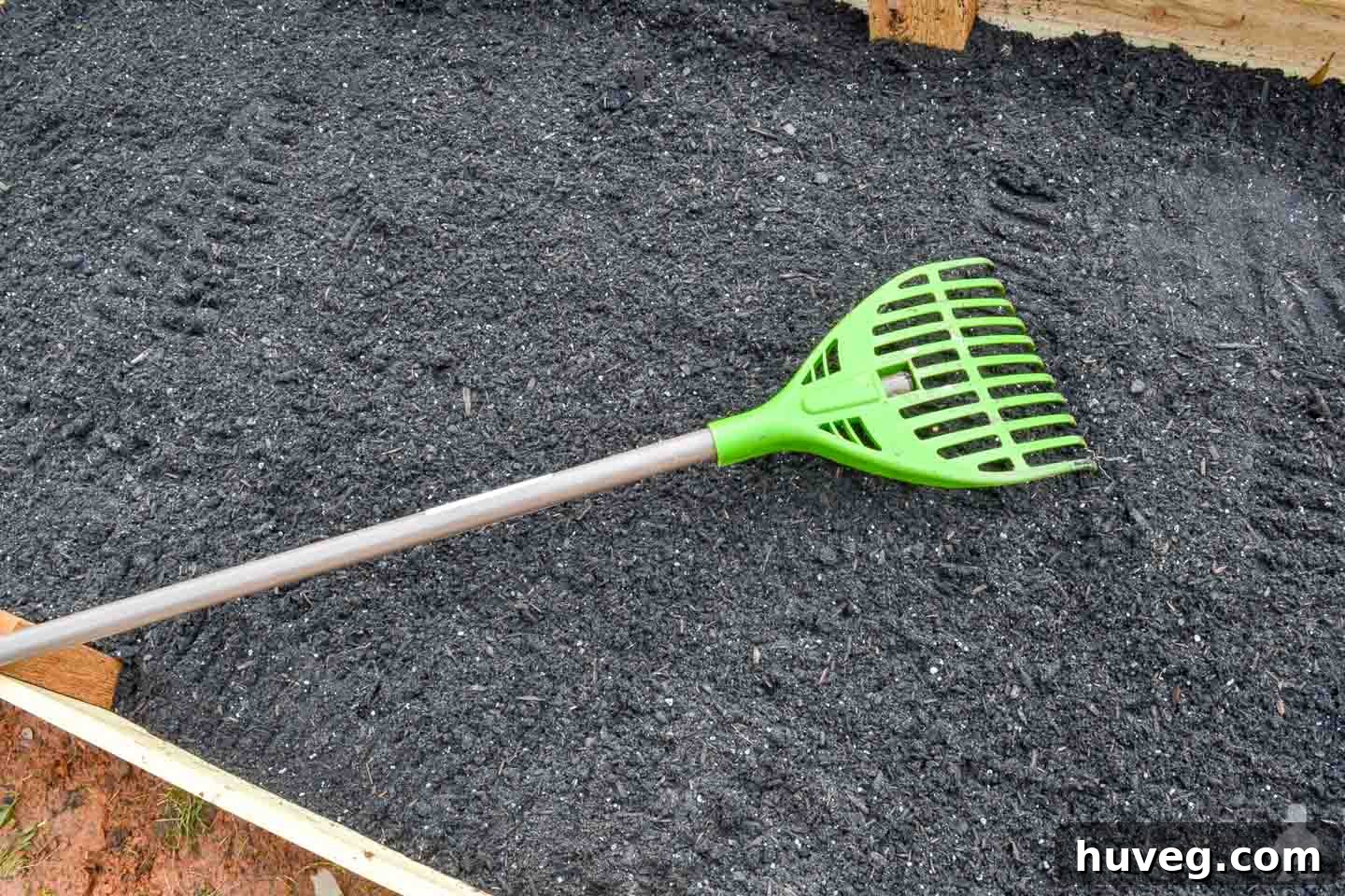 garden bed soil with green rake