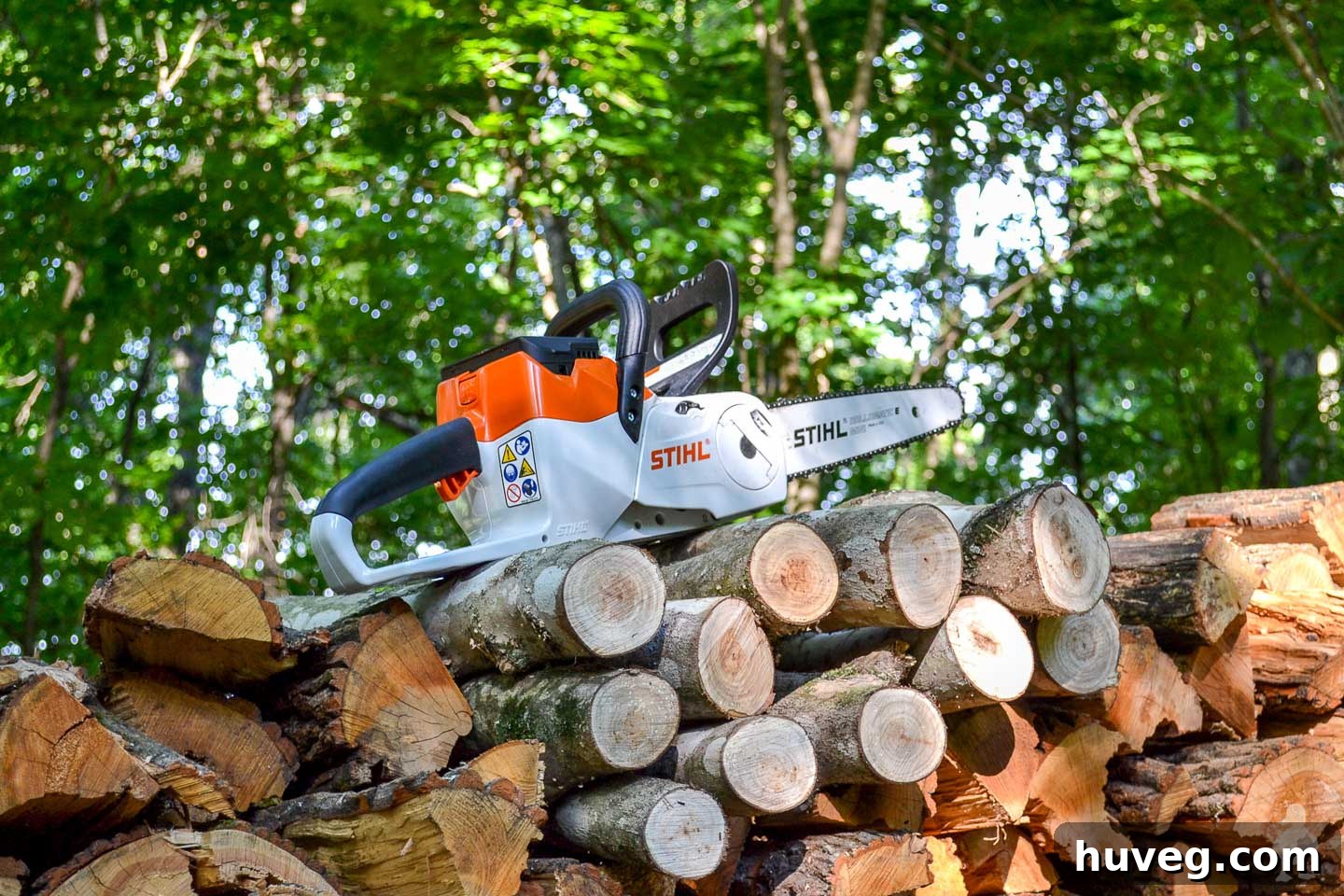 STIHL chainsaw resting on a stack of cut logs, ready for action.