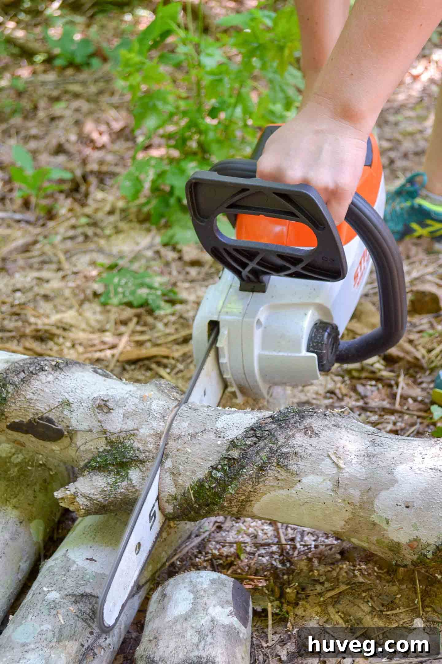 Close-up shot of a STIHL chainsaw expertly cutting through a thick log, sawdust flying.