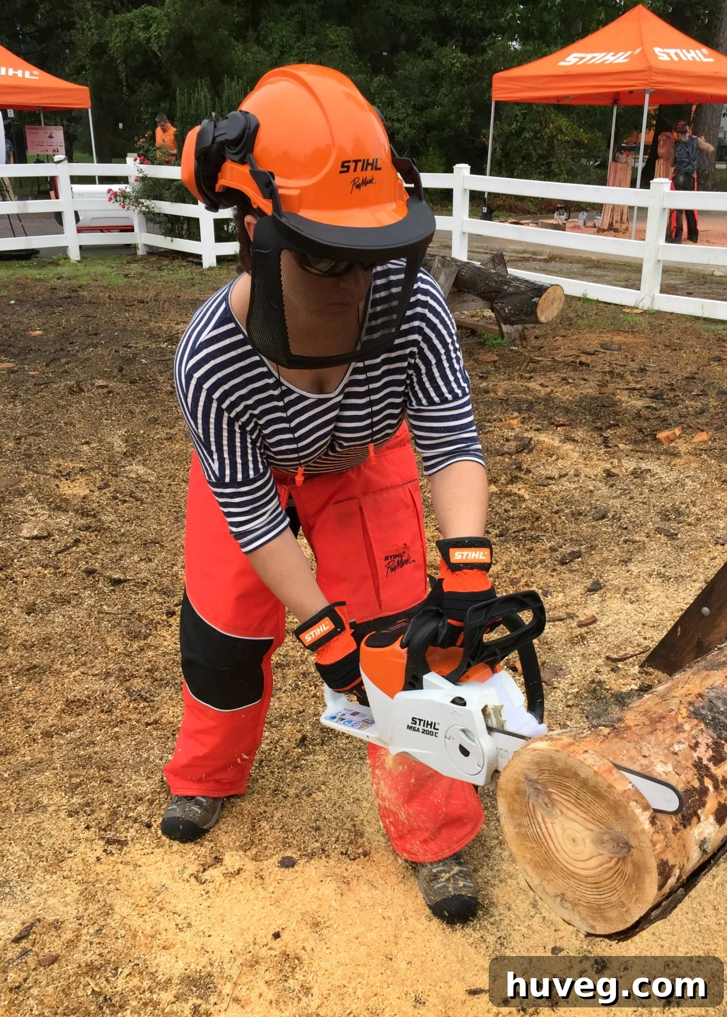 The author safely using a chainsaw to cut precise slices from a log, wearing full protective gear.