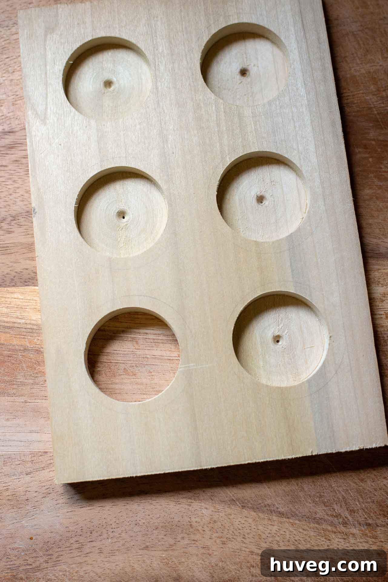 Holes drilled through wood to establish spots for k cups