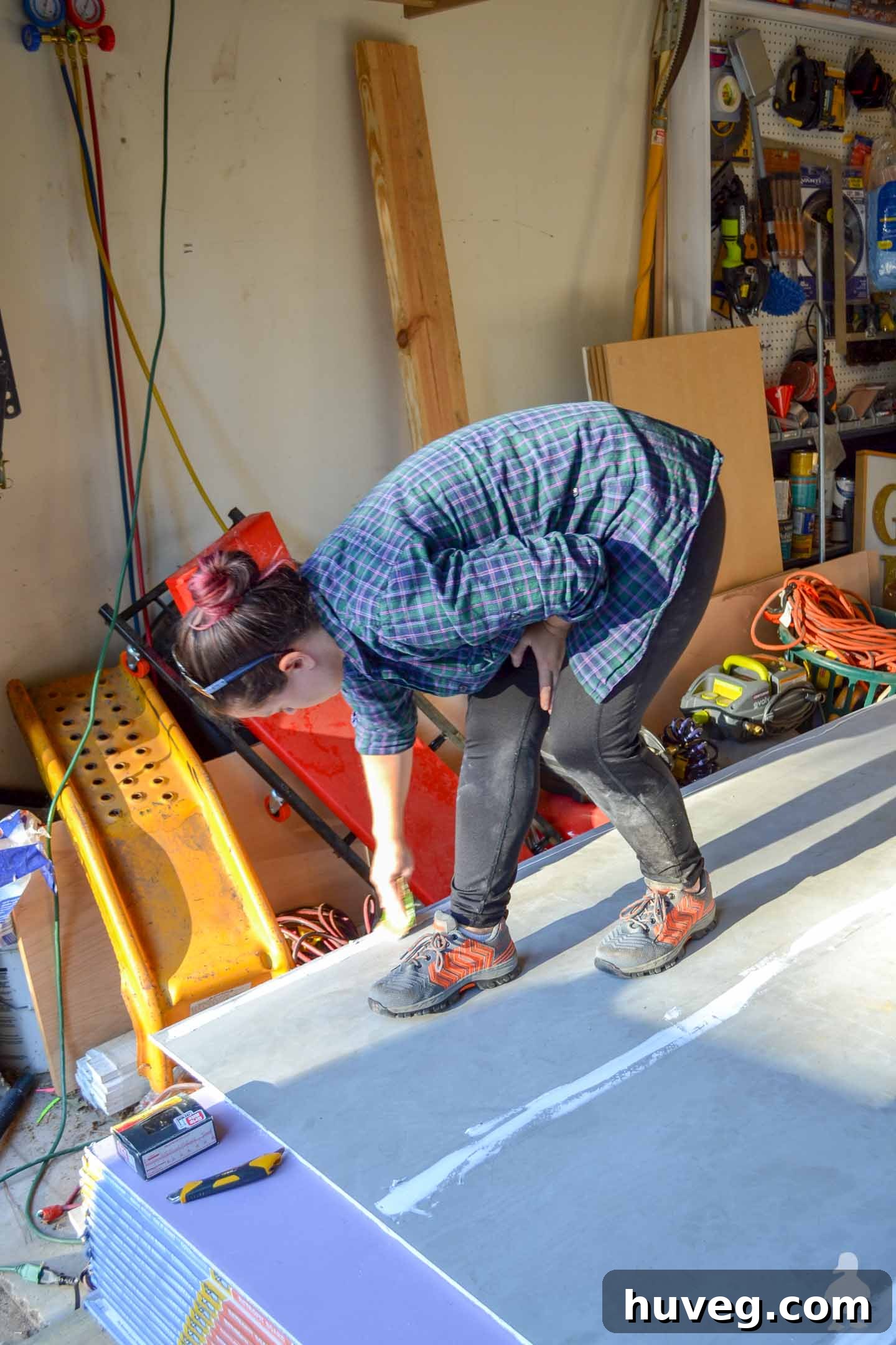 smoothing out adhesive on back of drywall
