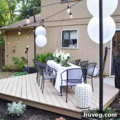 Black light pole planters with outdoor hanging lights illuminating a backyard floating deck for evening ambiance