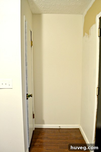A bright, freshly painted hallway leading to a staircase, showcasing the clean lines and renewed ambiance after a DIY painting project.