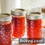filled jelly jars on white kitchen towel on counter with tiled backsplash