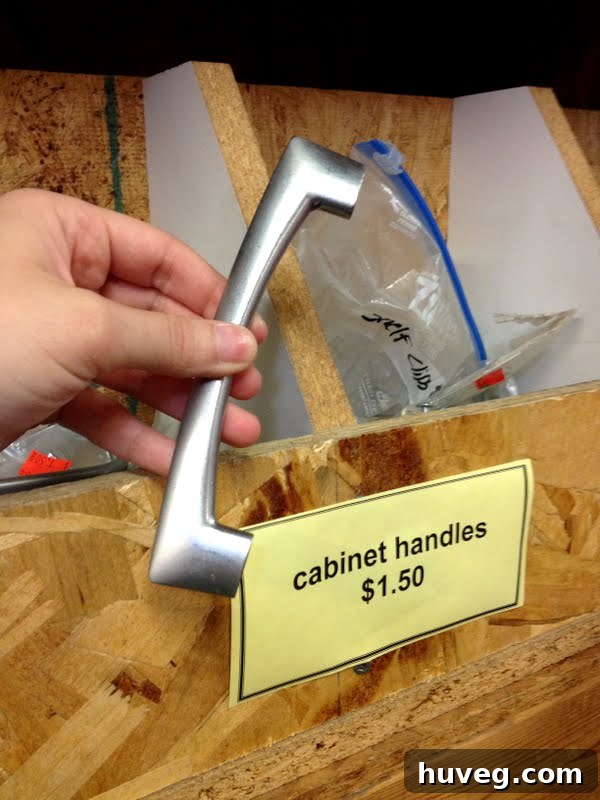 A selection of cabinet handles and drawer pulls at Habitat ReStore, showcasing various styles and finishes, neatly organized on a shelf.