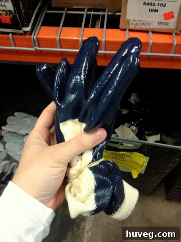 A close-up of a large bin filled with numerous pairs of blue nitrile-coated work gloves for sale at Habitat ReStore.