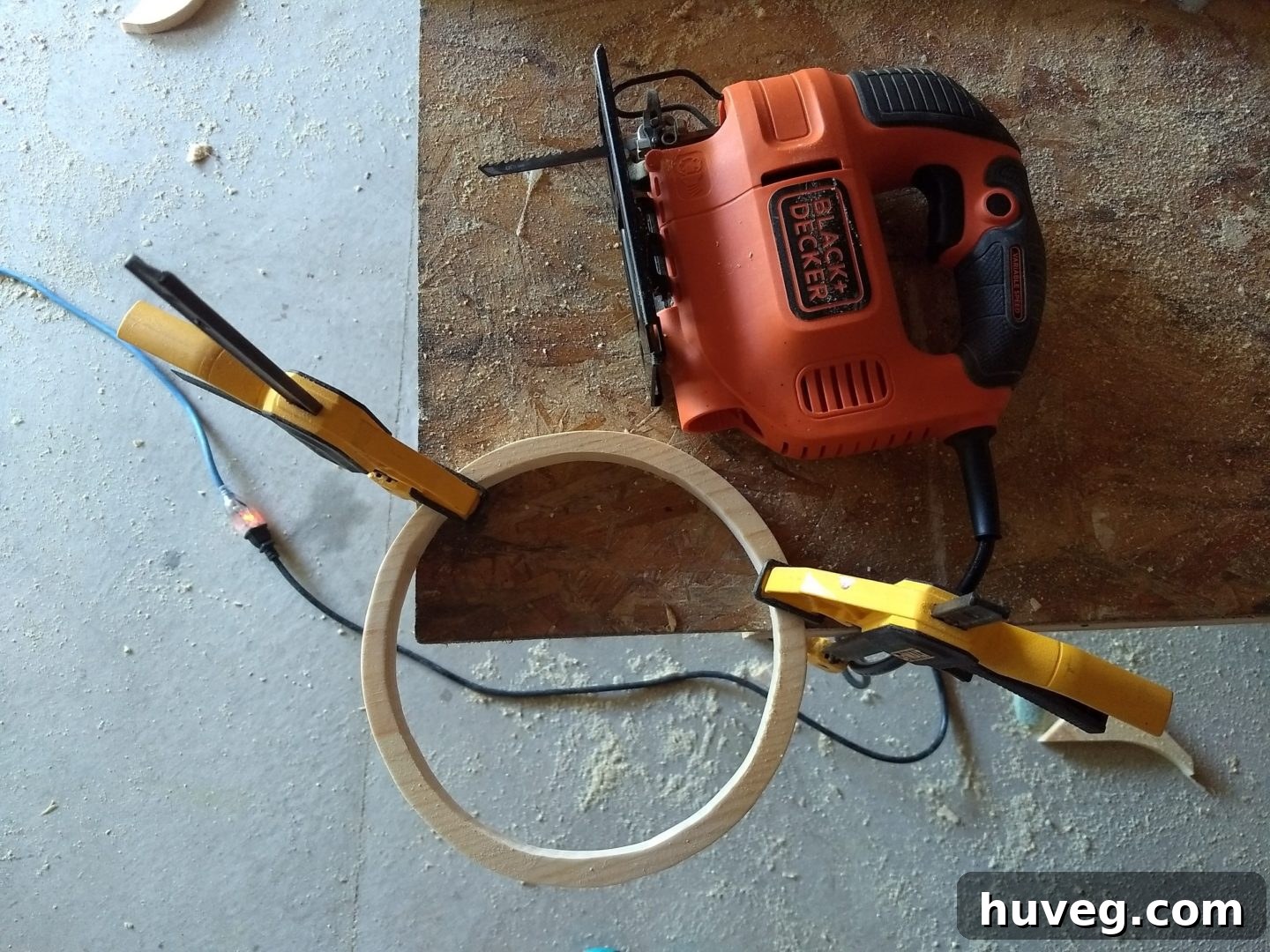 Cutting the inner circle of the mirror frame with a jigsaw after drilling a pilot hole, creating the opening for the round mirror to be recessed.