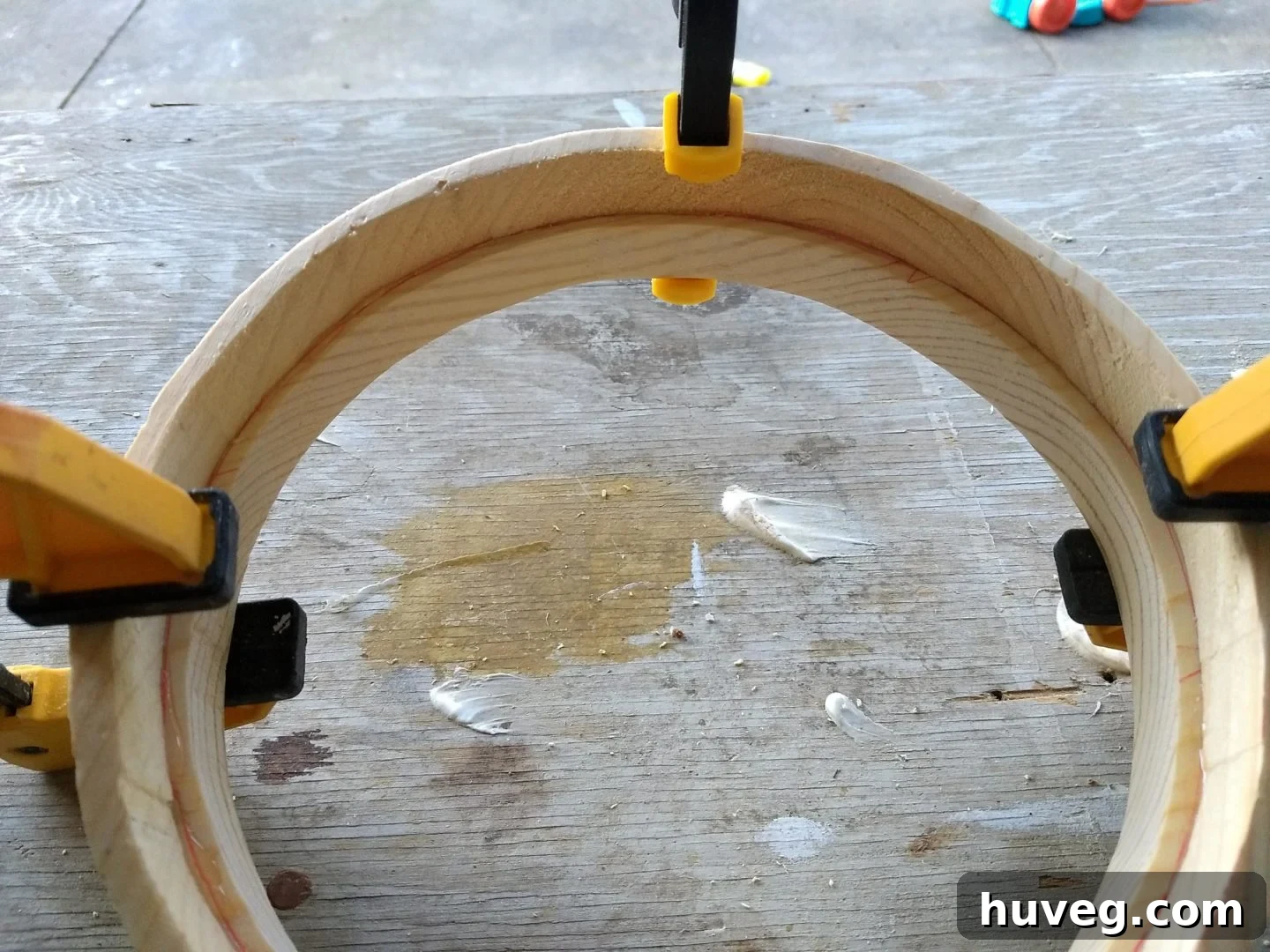 Applying wood glue between the two frame pieces before clamping them together, ensuring a strong and permanent bond for the DIY mirror frame.