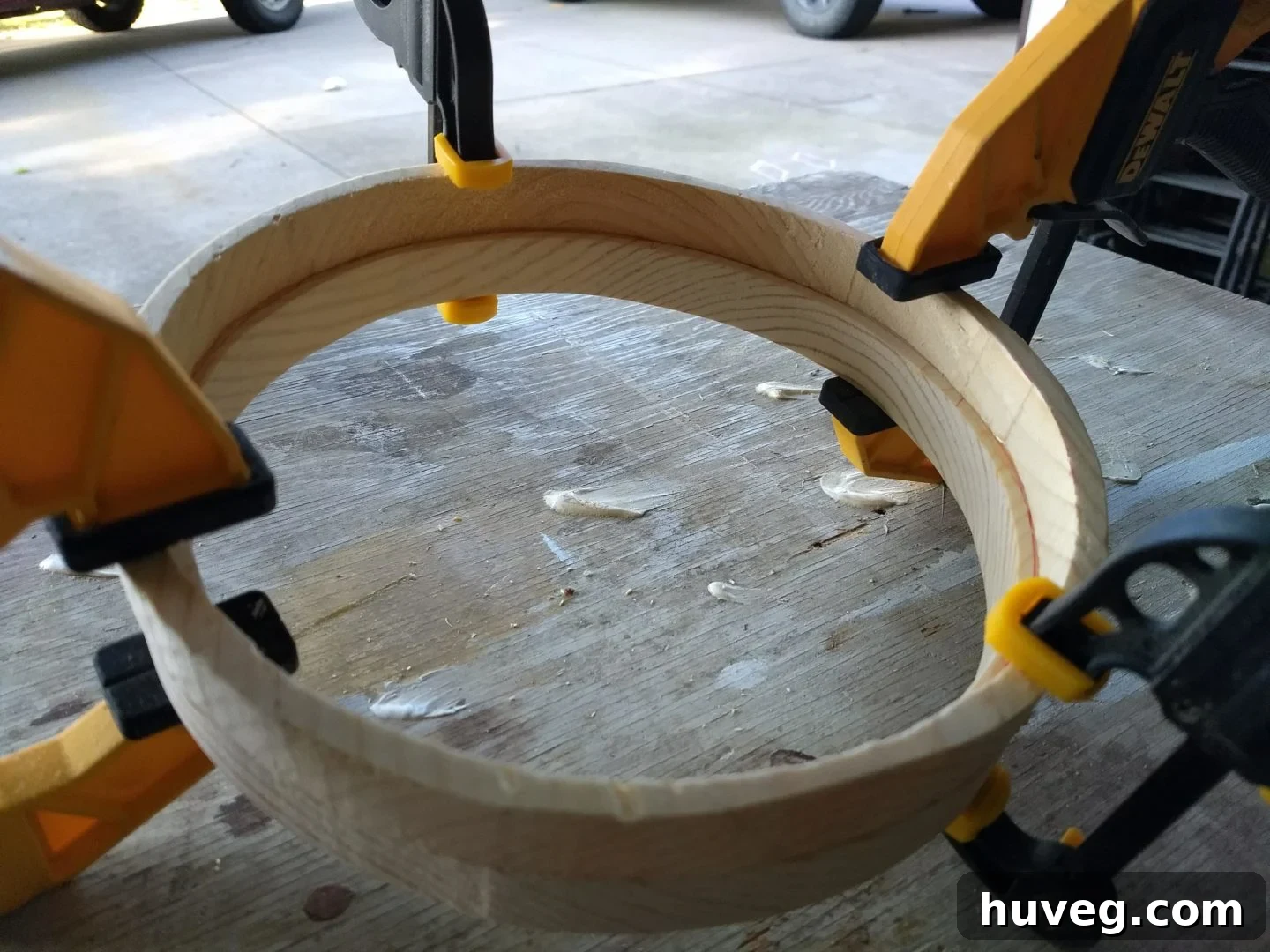 The two frame pieces securely clamped together after gluing, showcasing the precise alignment and the resulting recessed lip for the mirror.