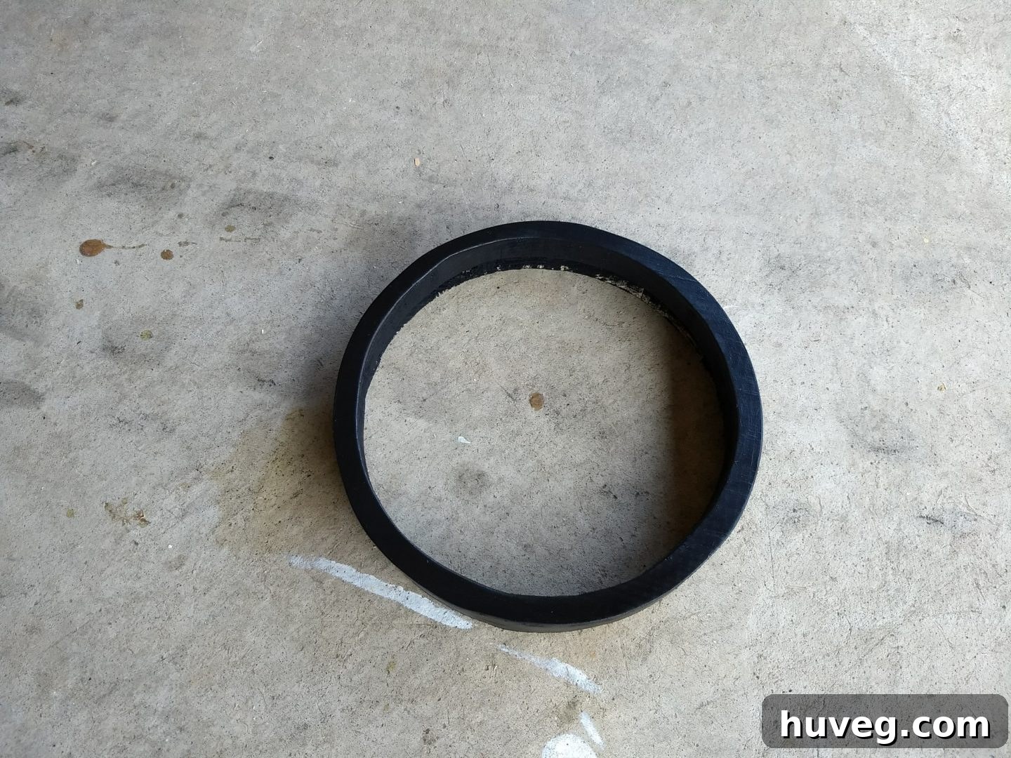 The round mirror frame after being sanded and painted black, sealed with glossy polyurethane for an industrial, sleek finish, ready for the mirror insertion.
