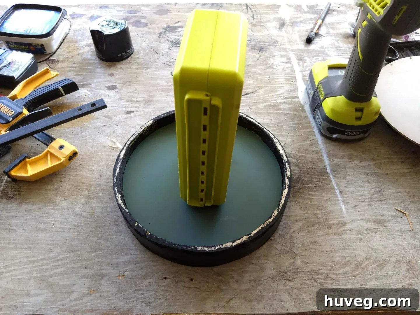 The mirror securely glued into the finished wooden frame, with weights applied to ensure proper adhesion while it dries.