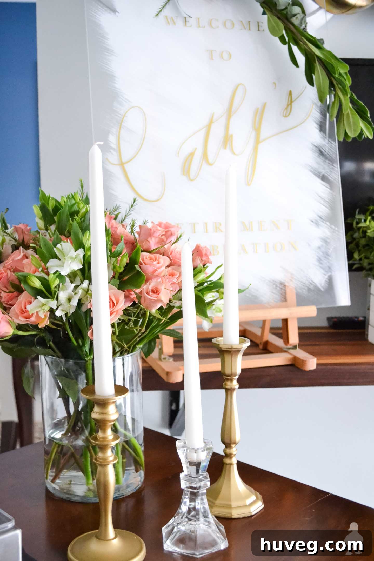 white tapered candles in gold candle holders and pink roses