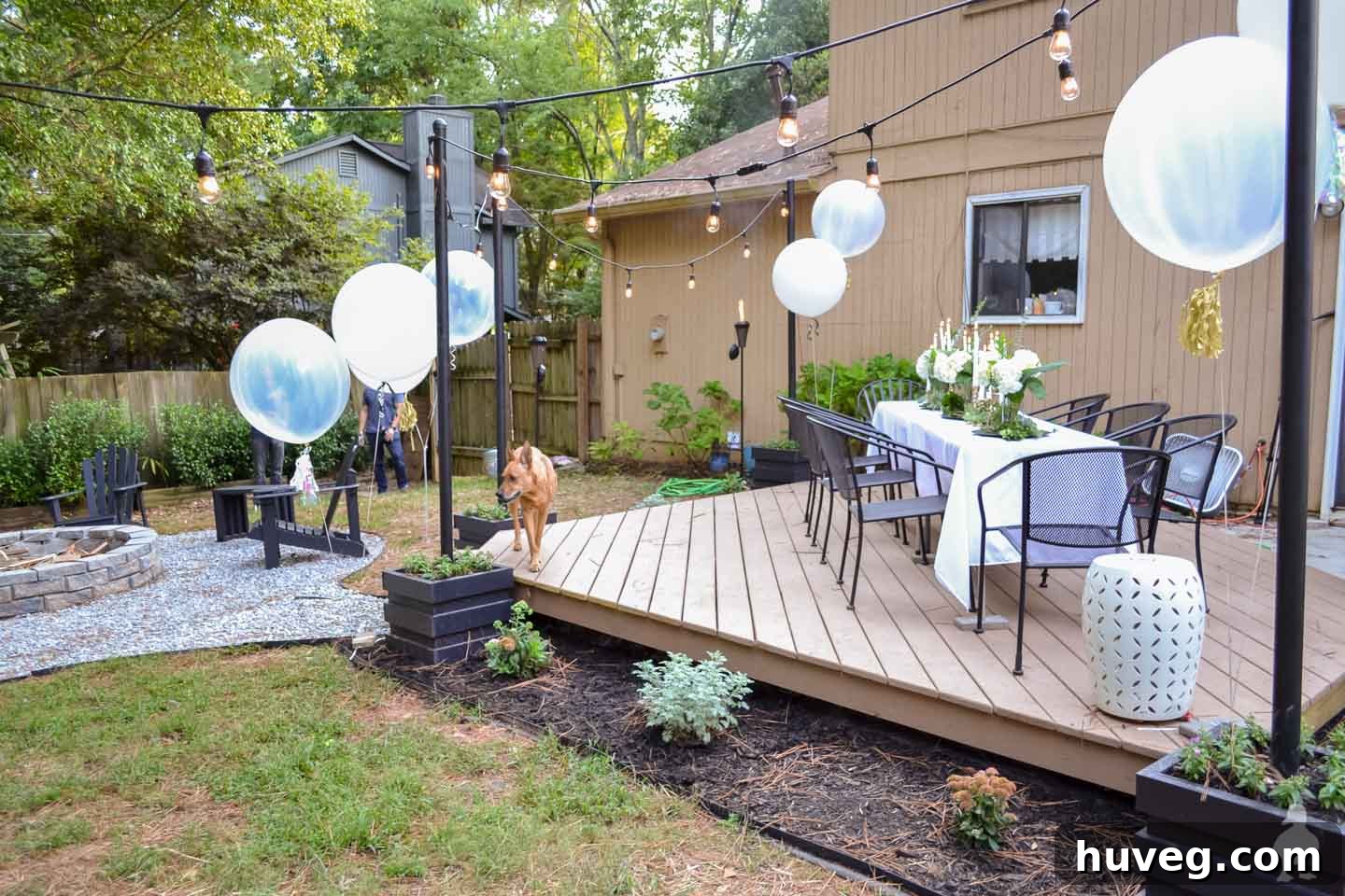 Tan Floating Deck with Landscaping, White Table, White Balloons, and Hanging Lights