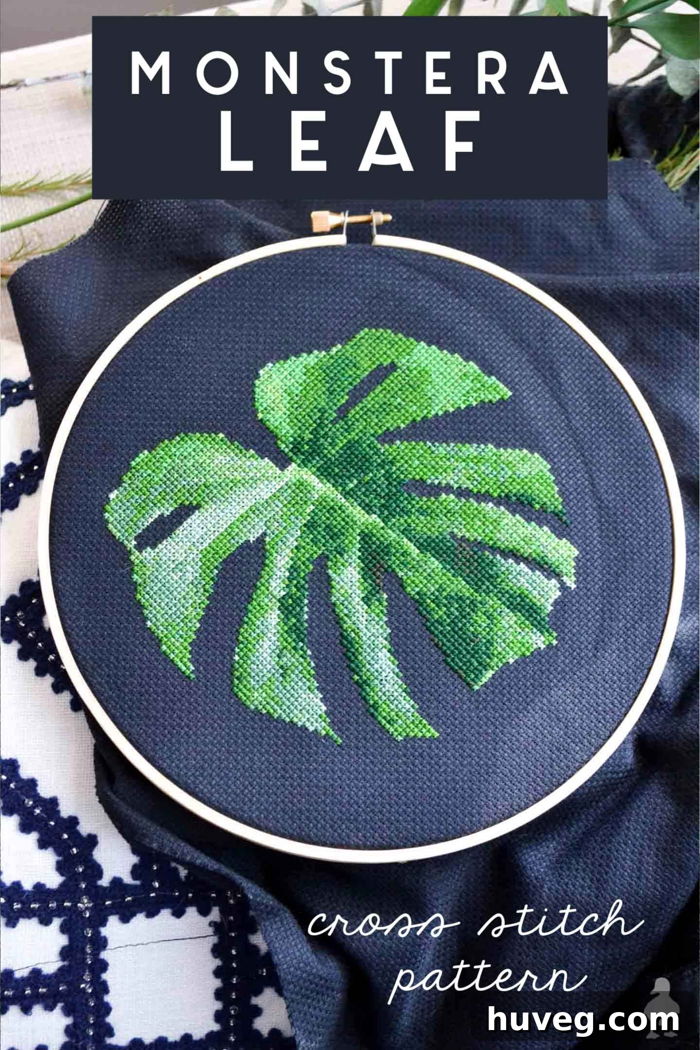 Vibrant Monstera leaf cross stitch pattern on dark fabric, a modern take on botanical fiber art.