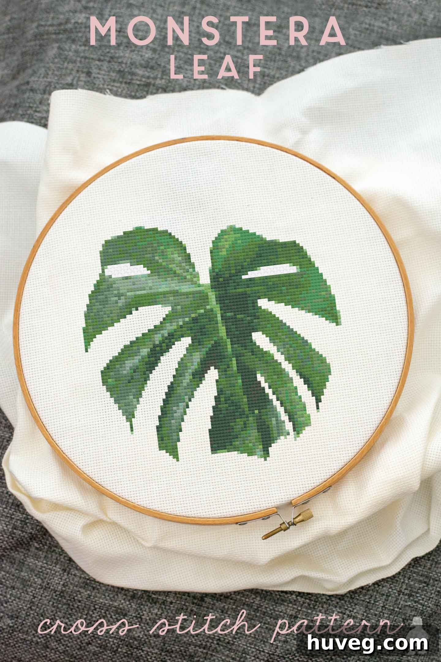 Completed Swiss Cheese Plant leaf cross stitch pattern, beautifully displayed on a pristine white fabric.