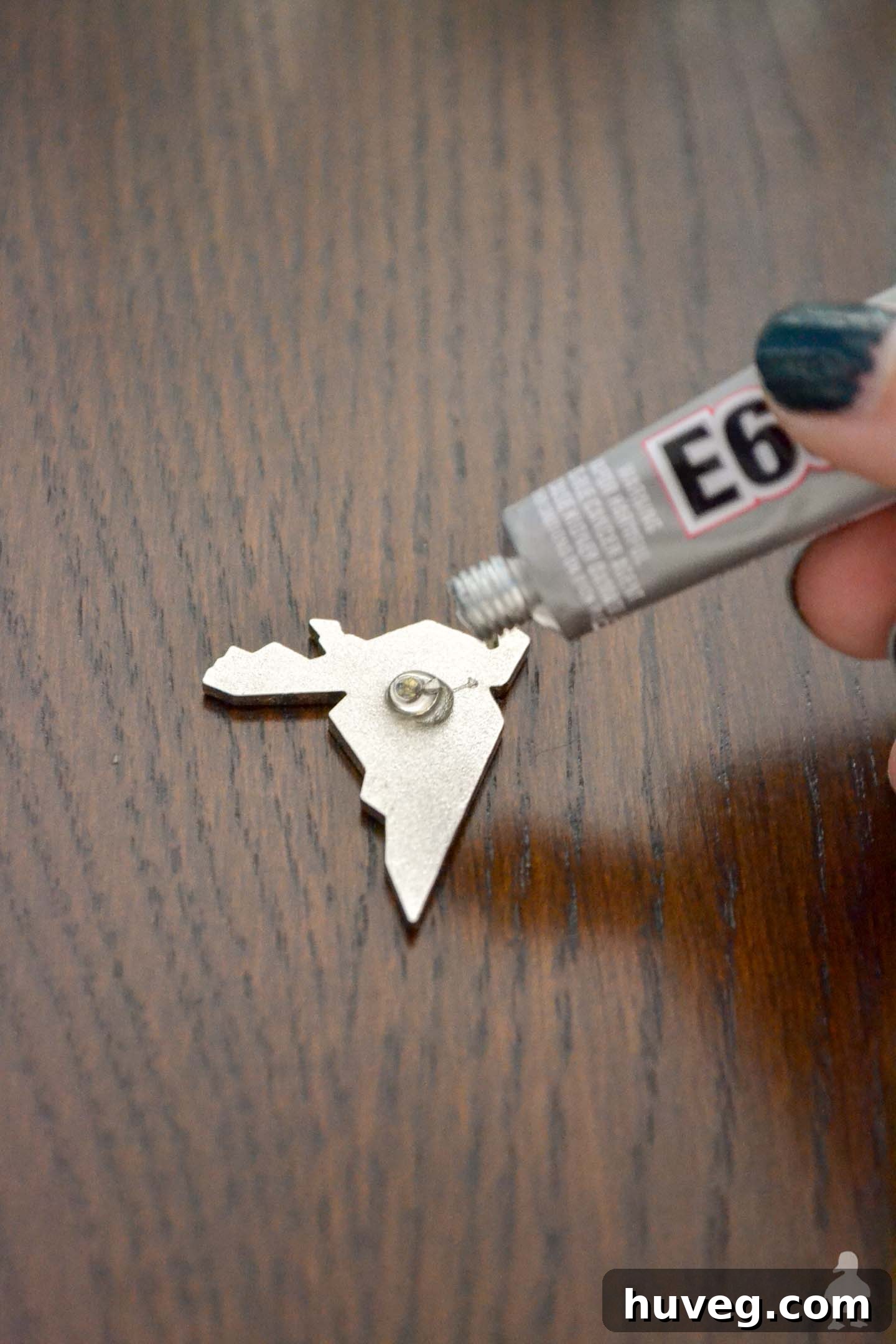 Applying a generous amount of glue to the back of the lapel pin after removing the prong.