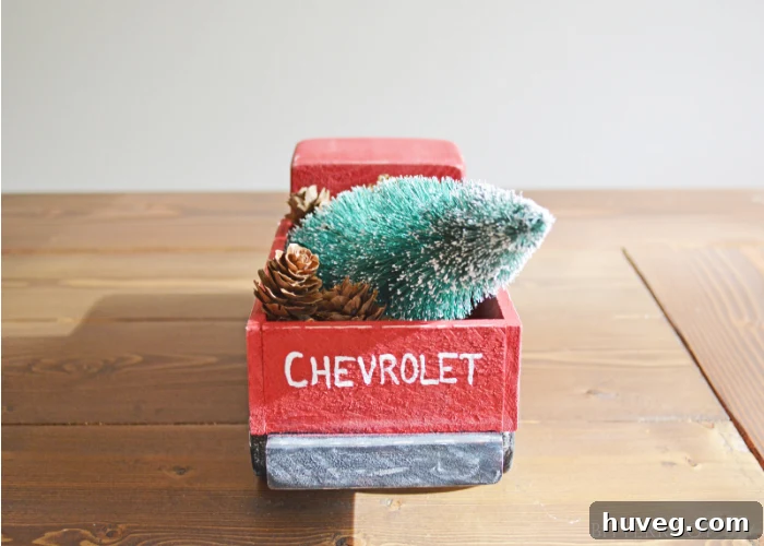 Completed DIY Vintage Christmas Truck with a mini Christmas tree and pine cones in the bed