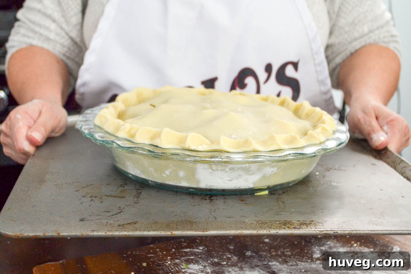 mom holding pan with apple pie ready to bake