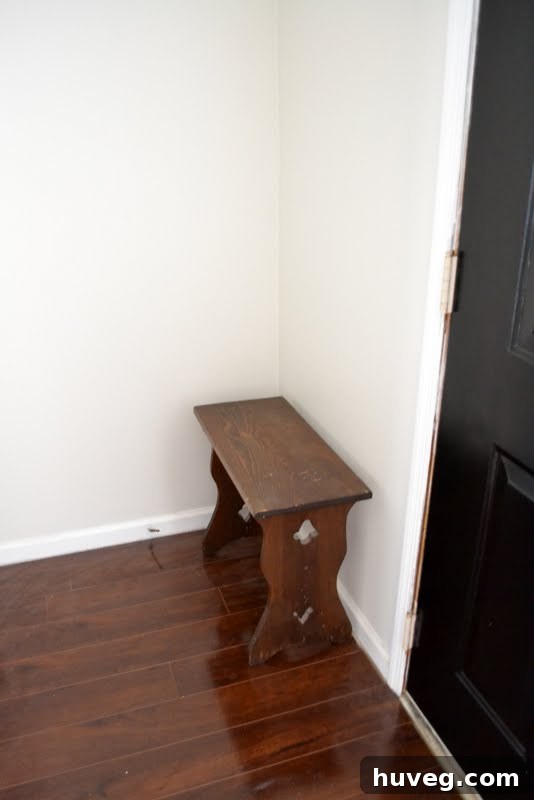 Newly painted greige entryway with small wooden bench