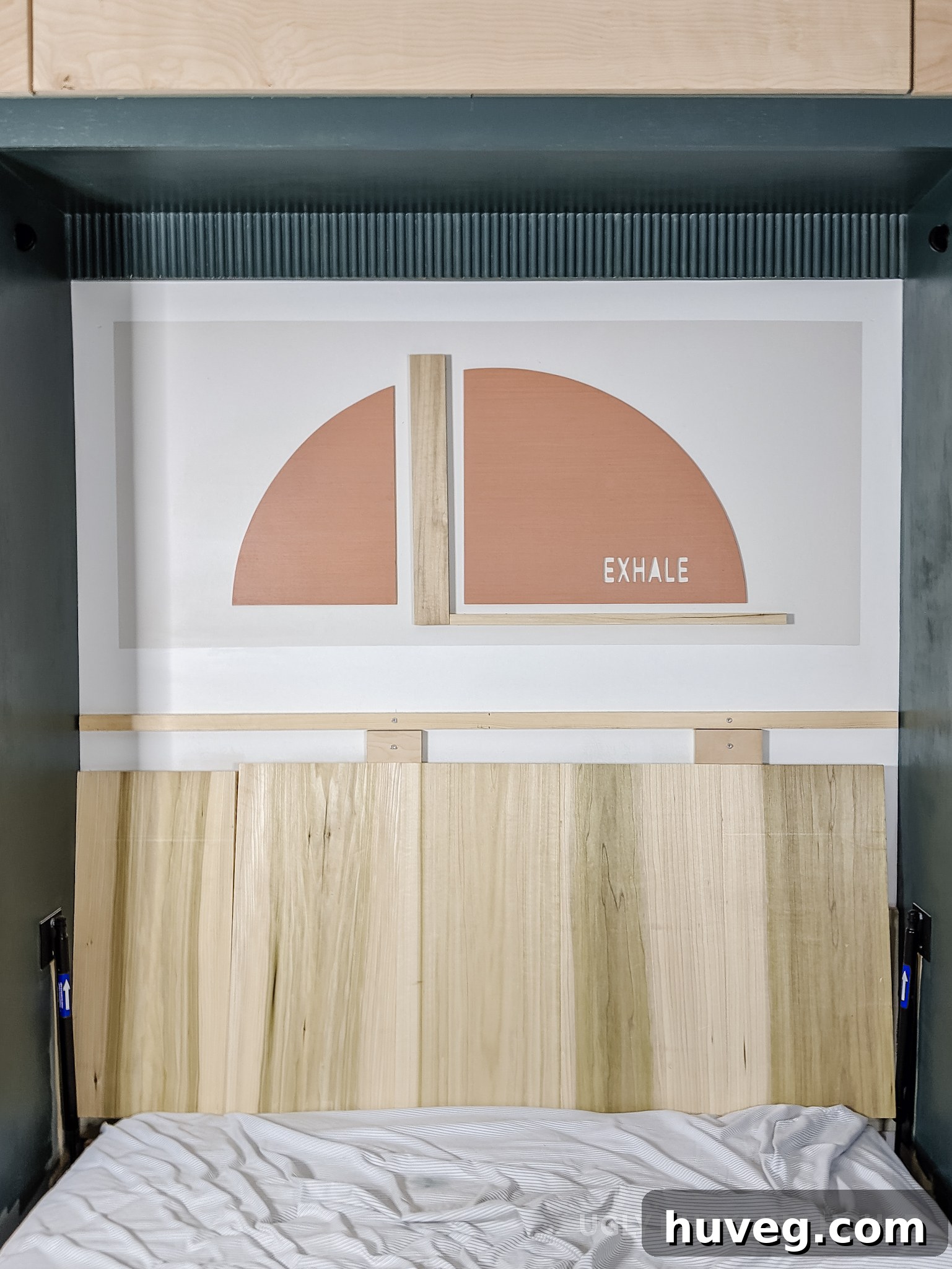 Finished Murphy bed nook featuring the 'Exhale' stained wood art and a carved headboard, protected with polycrylic