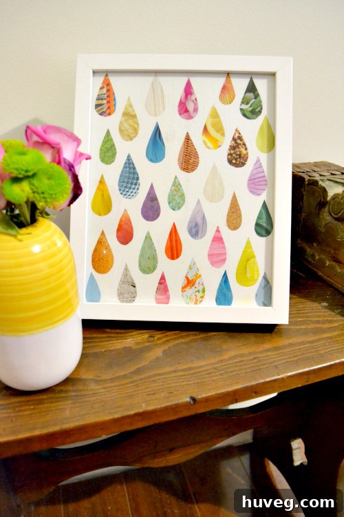 Finished DIY raindrop art in a white frame, beautifully displayed as home decor in a hallway