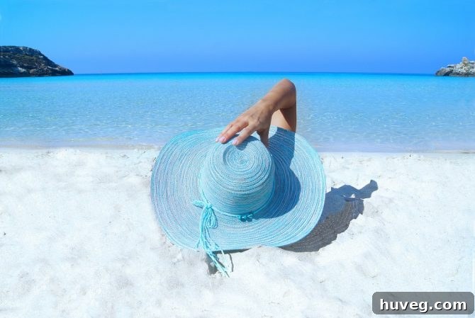 A straw beach hat resting on a sandy beach, hinting at relaxation and escape amidst clear blue waters.