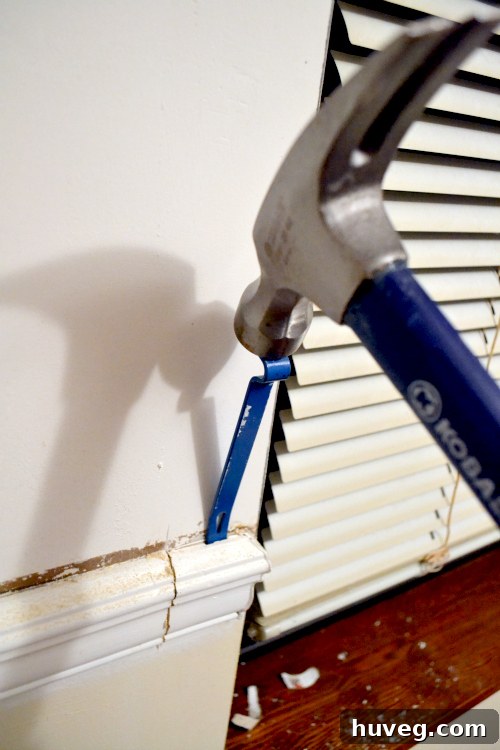 Using a pry bar to remove chair rail