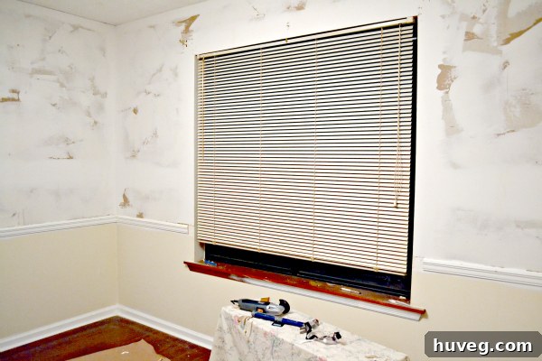 Dining room window without trim, showing old blinds
