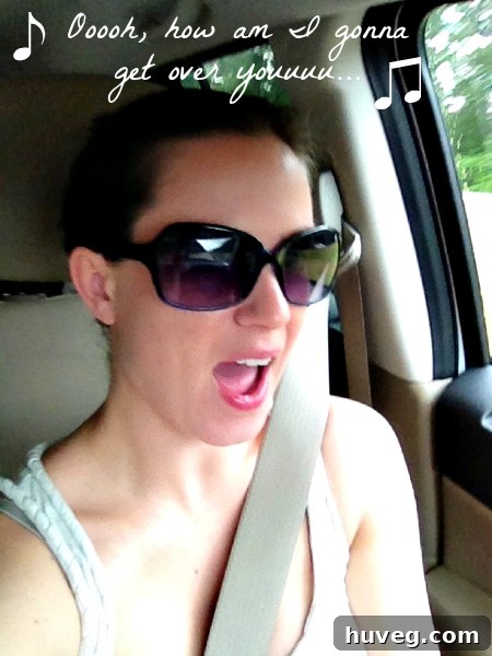 Woman happily singing in a car, enjoying her solo road trip