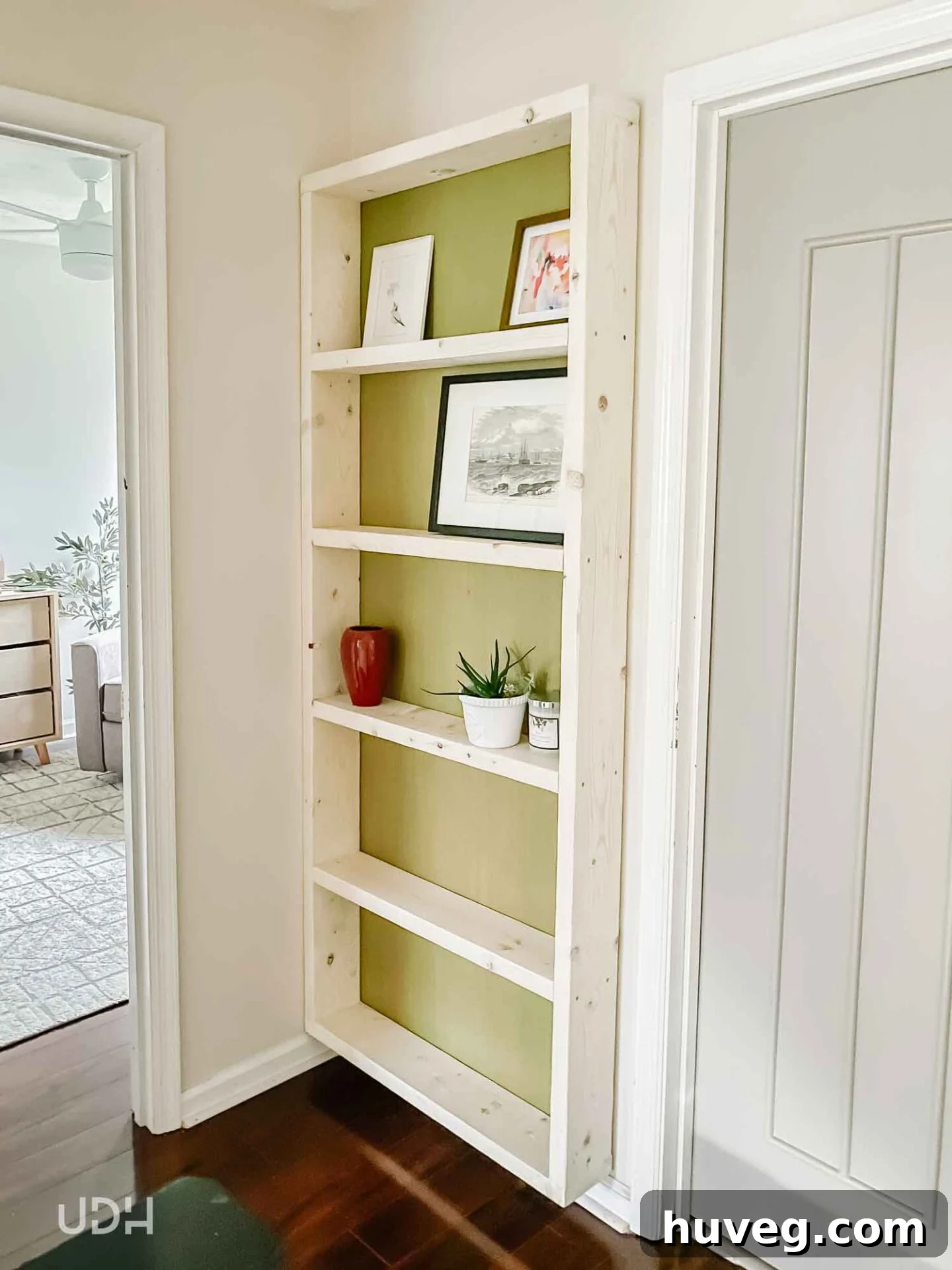 Elegant solid wood floating bookcase with a vibrant green backer, perfectly integrated into a hallway for maximum storage and style.