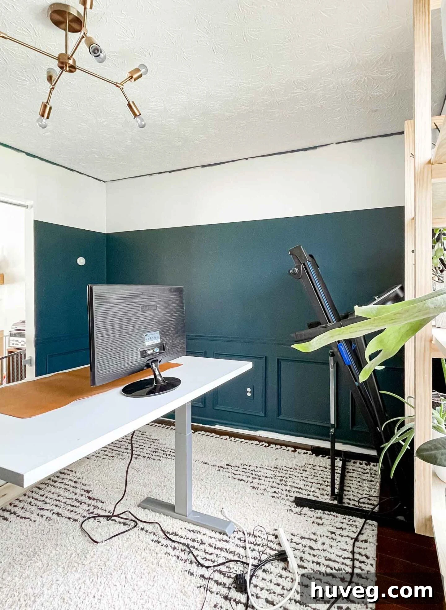 Home office with three-quarter color block walls featuring Sherwin-Williams Newburg Green, a modern DIY design