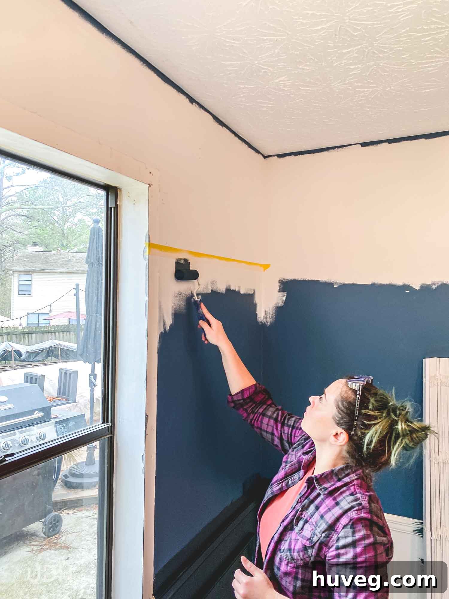 Using painters tape to create sharp color block walls, demonstrating the sealing technique