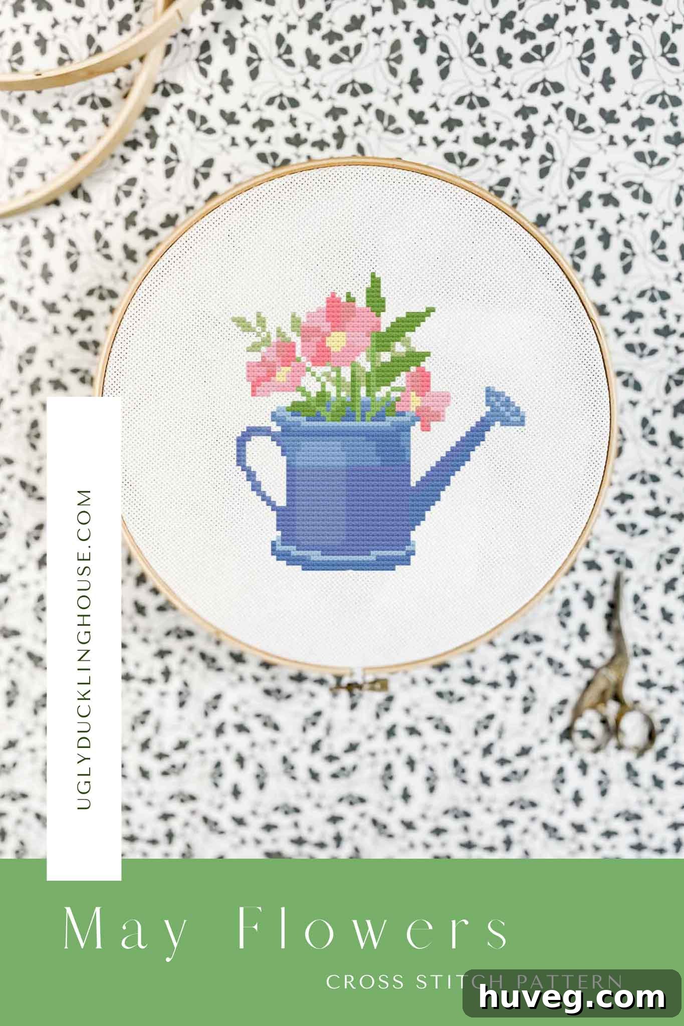 Beautiful May Flowers cross stitch pattern featuring a rustic watering can overflowing with blooming flowers in a vibrant spring palette