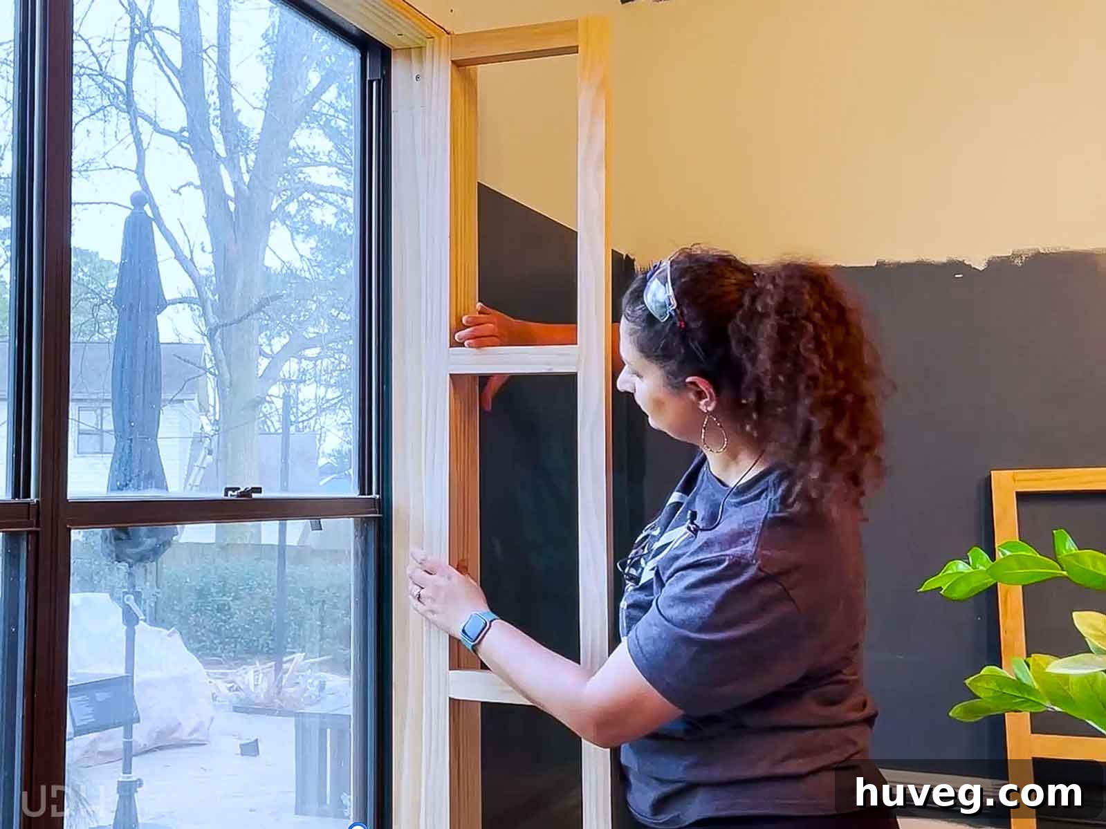 Anika skillfully inserting and securing shelf supports into the window frame